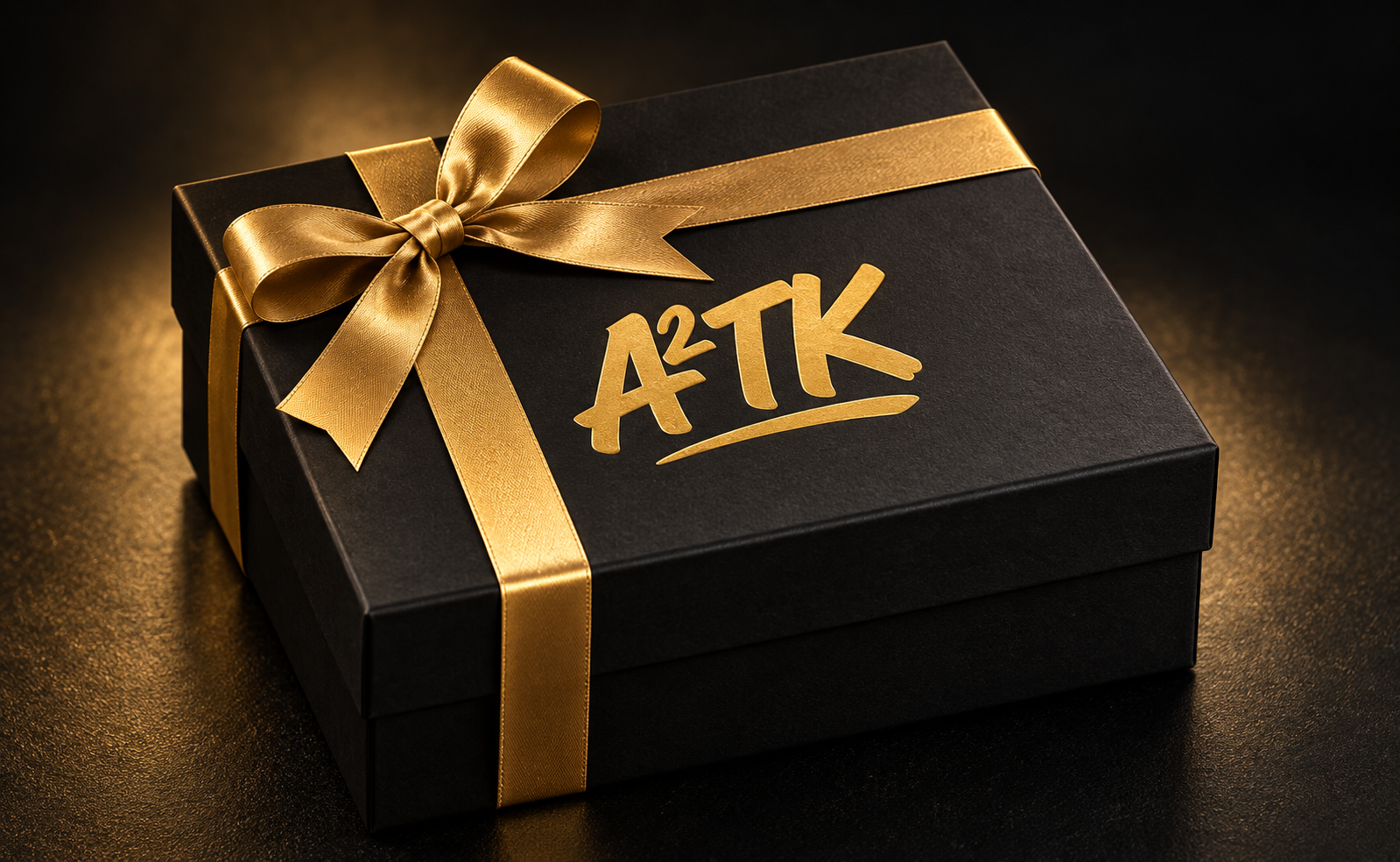 Matte black A2TK mystery gift box wrapped with a gold ribbon
